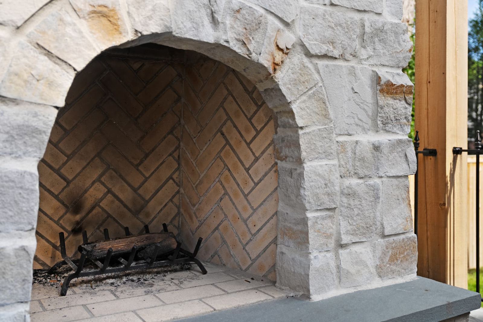 Arched stone fireplace with herringbone brick firebox