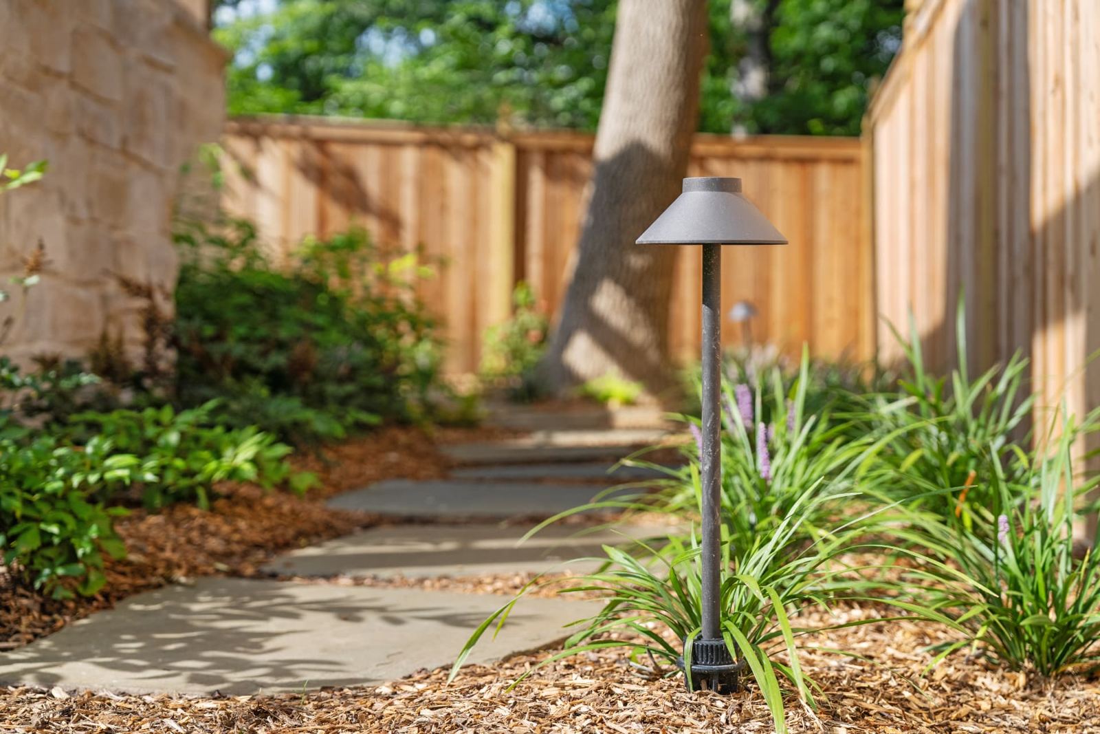 Bluestone stepping-stone path through planted beds with path lighting