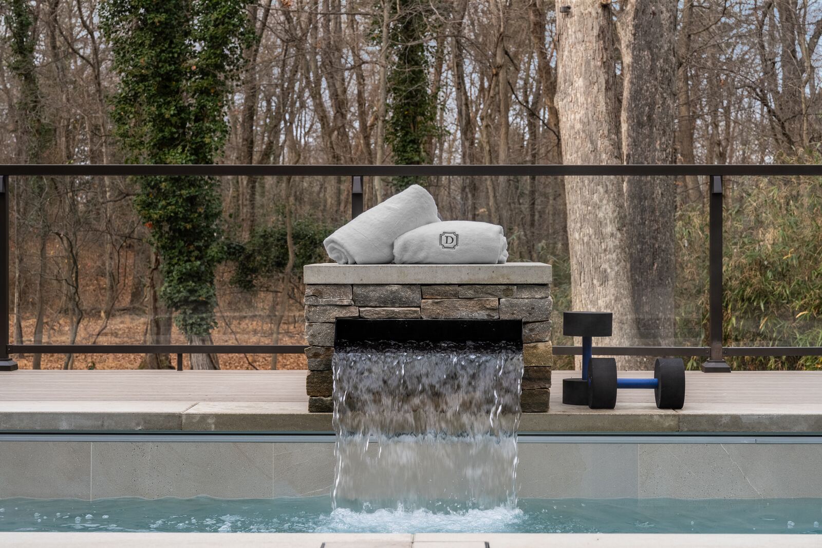 Water pouring from a stacked-stone spillover into a plunge pool